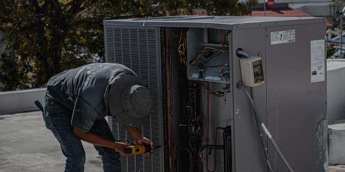 Licensed HVAC technician repairing an outdoor AC unit in Tampa, FL